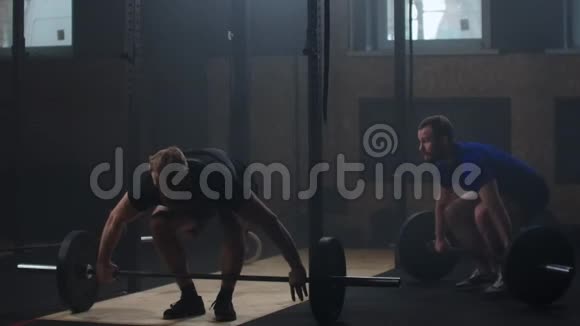 两个强壮的男子在健身房做杠铃运动视频的预览图