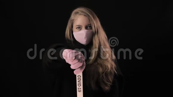 穿着粉红色面具的女孩拿着一条带着铭文的带子19号孤立在黑色背景上保健和医疗视频的预览图