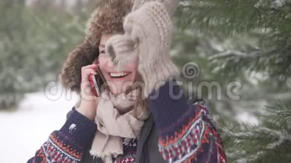 一个女人在雪地森林里用手机说话视频的预览图
