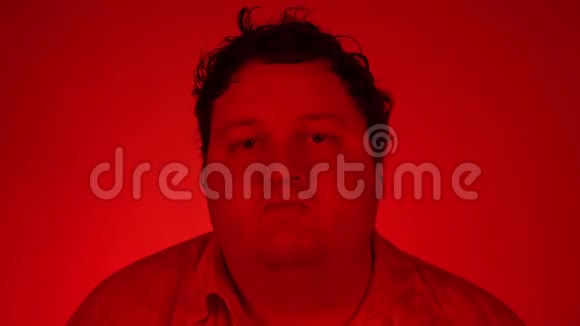 胖子在红色背景下孤立地跳舞带有红色灯光的肖像视频的预览图