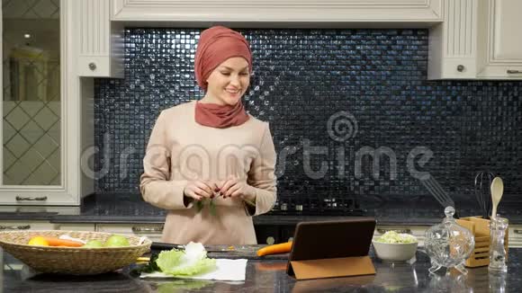 女士戴头巾和亲戚通过Skype做晚餐视频的预览图