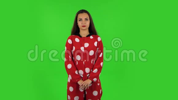 美丽的女孩穿着红色羊毛睡衣站着微笑着散开绿色屏幕视频的预览图