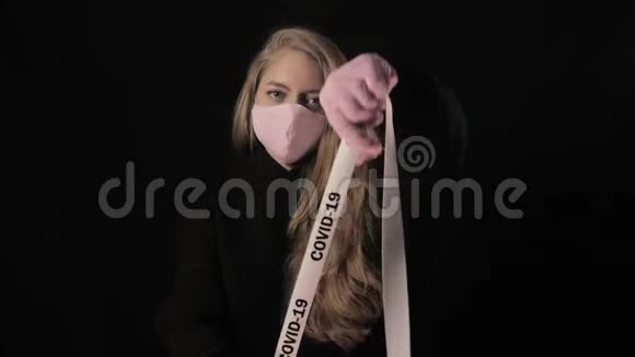 穿着粉红色面具的女孩拿着一条带着铭文的带子19号孤立在黑色背景上保健和医疗视频的预览图