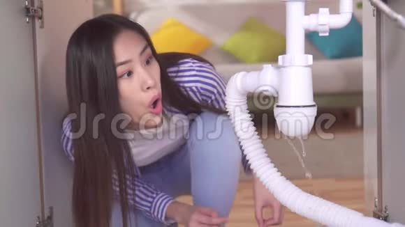 令人惊讶的是年轻的亚洲女人看到水槽下面有一个漏水的慢潮视频的预览图