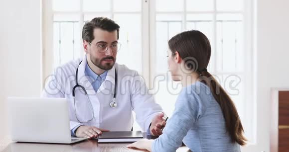 专业男性医生为年轻女性病人看病视频的预览图