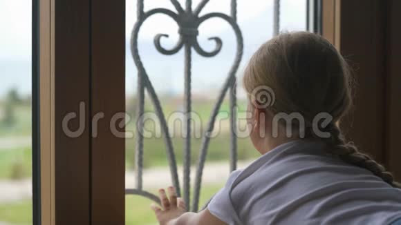 呆在家里预防冠状病毒大流行女孩望着窗外却不能出去寻找视频的预览图