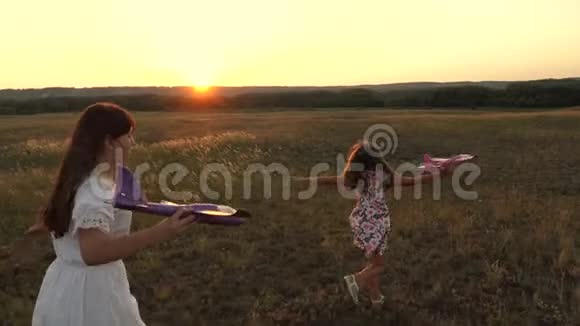 孩子们手里拿着飞机在草地上飞行的梦想快乐童年的概念两个女孩玩视频的预览图