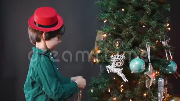这个男孩把圣诞树玩具挂在圣诞树上视频的预览图