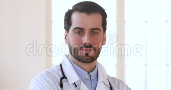 微笑自信男医生穿着白色制服看着镜头视频的预览图