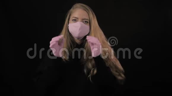 穿粉色医用口罩的女孩摘下口罩咳嗽孤立在黑色背景上保健和医疗概念视频的预览图