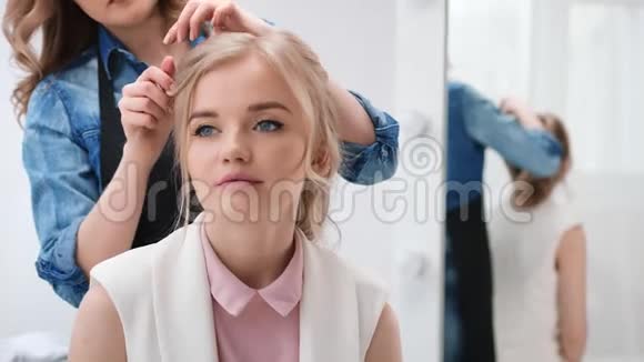 在美容院做发型时特写年轻女孩的肖像4K红色相机拍摄视频的预览图