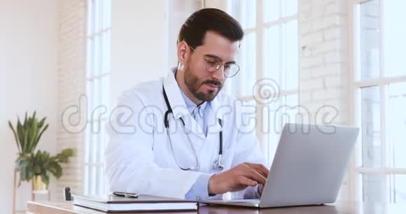 男性专业医生穿着医用外套手提电脑视频的预览图