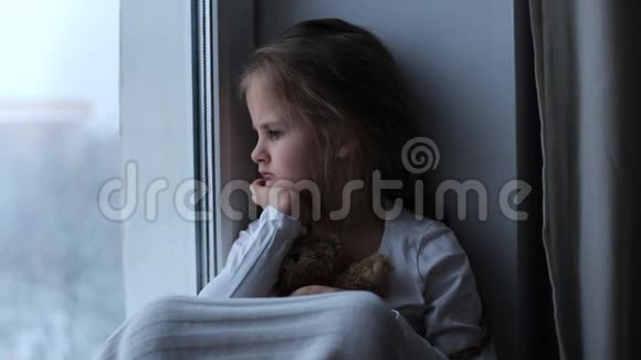 悲伤孤独的孩子抱着一只玩具熊视频的预览图