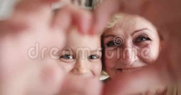 多情的祖母和孙女看着镜头做了个心脏手势视频的预览图