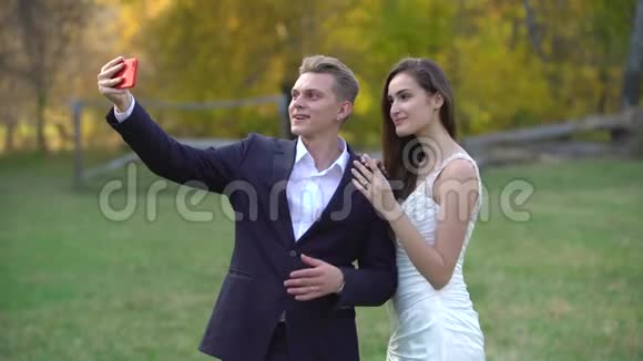 新婚夫妇在阳光明媚的秋天风景背景下在电话里自拍视频的预览图