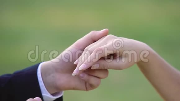 把漂亮的戒指戴在新娘的手指上亲吻她的手关门视频的预览图