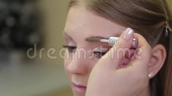 专业化妆师用特殊的画笔向客户画眉毛视频的预览图