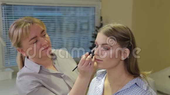 专业化妆师用特殊的画笔向客户画眉毛视频的预览图
