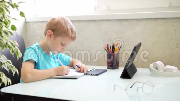 小男孩在家用平板电脑学习检疫方面的远程学习隔离家庭作业视频的预览图