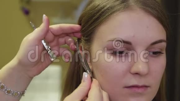 专业的理发师把发夹放在女孩的头上视频的预览图