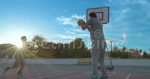 父亲和儿子用太阳光棒打篮球视频的预览图