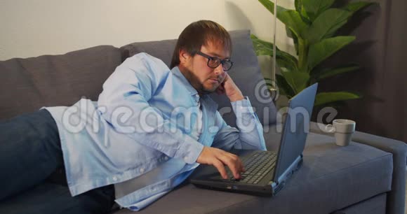 戴眼镜的商人带着笔记本电脑在办公室喝咖啡或茶商业人员和技术概念视频的预览图