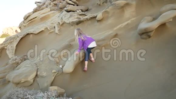 女孩能爬上光滑的沙岩视频的预览图