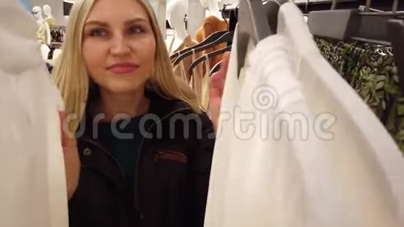 女孩在商场里挑选衣服视频的预览图