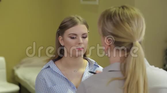 专业化妆师在客户嘴唇上刷口红视频的预览图