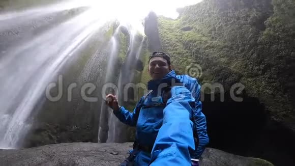 背包客在洞穴中探索著名的旅游大瀑布Gljufrabui慢动作冰岛视频的预览图