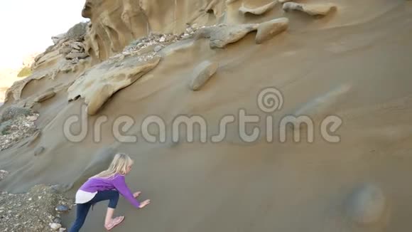 女孩滑倒试图爬上光滑的沙岩视频的预览图