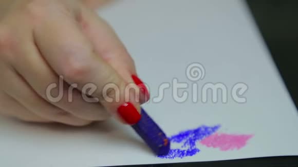 女性的手在白纸上画蓝色的粉彩时间视频的预览图