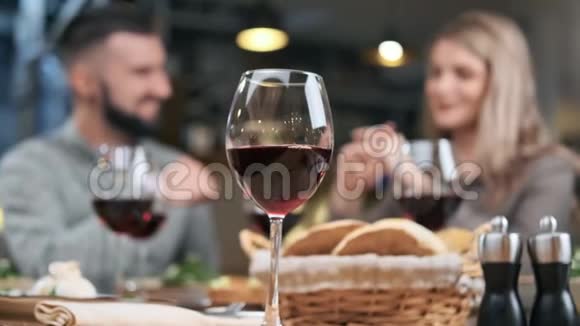 在餐厅的年轻夫妇晚餐时把酒杯放在桌上4K红色相机拍摄视频的预览图