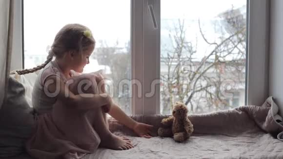 女孩坐在窗台上玩他的玩具视频的预览图