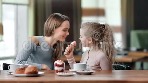 快乐的母亲和女儿一起在咖啡馆吃甜点玩得很开心中型摄影机视频的预览图