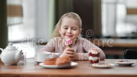 快乐无忧无虑的女孩子拿着冰淇淋甜点坐在自助餐厅4k龙红相机视频的预览图