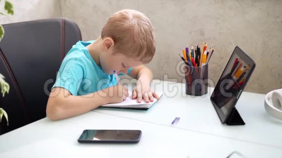 小男孩在家用平板电脑学习检疫方面的远程学习隔离家庭作业视频的预览图