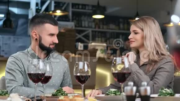 嬉皮笑脸的男人和漂亮的女人在餐厅的晚餐约会4k龙红相机视频的预览图