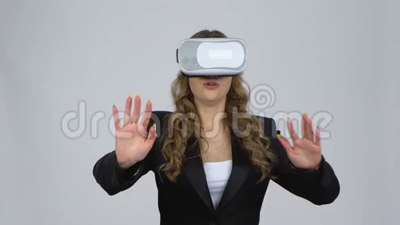 快乐的年轻女子与虚拟现实耳机或3D眼镜灰色背景在工作室视频的预览图