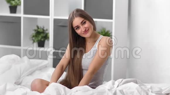 家庭金发女孩的肖像美丽的长发在卧室摆姿势中型摄影机视频的预览图