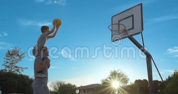 父亲和儿子在公园里玩一天打篮球视频的预览图