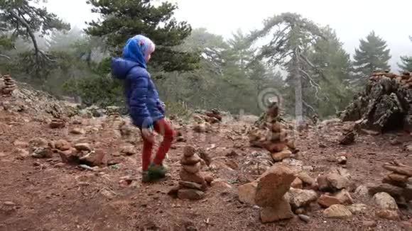 一个女孩走在奥林匹斯山上游客布置的石雕之旅中视频的预览图