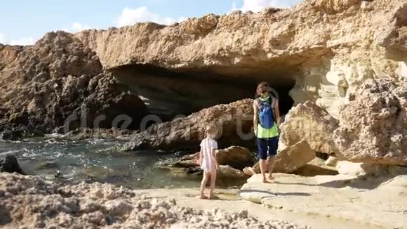 妈妈和女儿在石窟附近检查岩石地中海视频的预览图