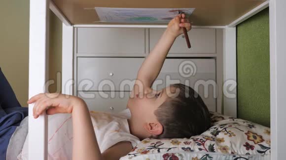 男孩画倒了居家休闲活动室内学龄前儿童躺在桌子下面画画小画家视频的预览图