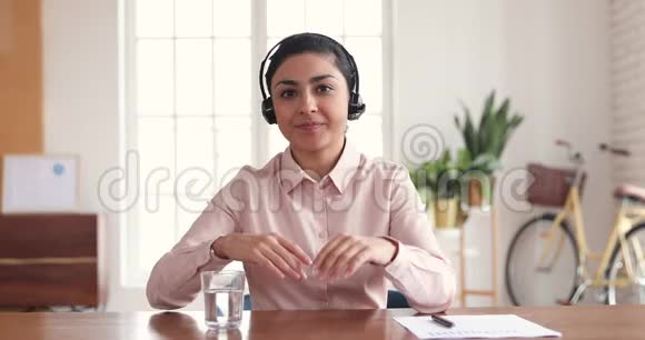 自信的印度女商人戴着耳机与摄像头会议通话视频的预览图