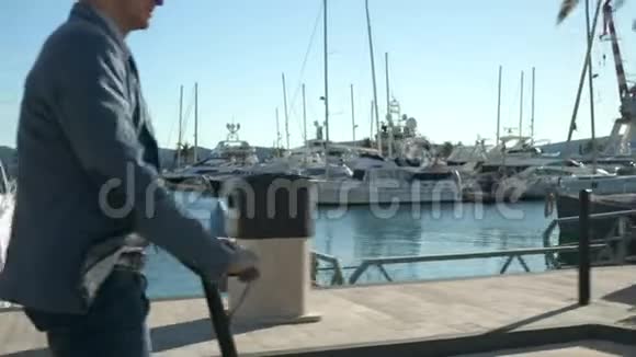 英俊的商人在游艇系泊中驾驶滑板车视频的预览图