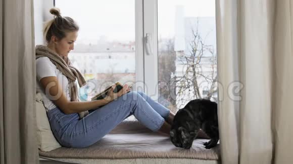 一个女孩坐在窗台上热情地看书视频的预览图