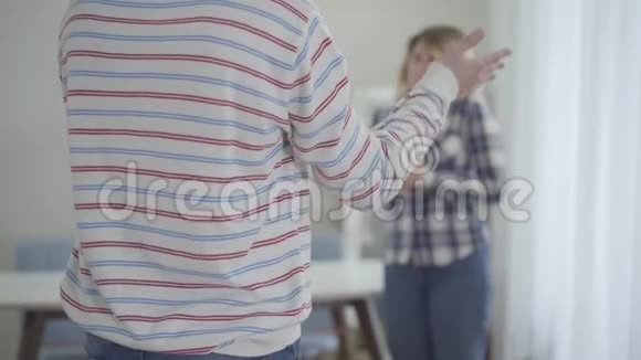 在背景下无法辨认的白人青年男子对模糊的女人做手势和大喊大叫愤怒的丈夫视频的预览图