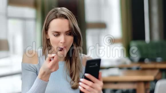 女士在咖啡馆享用午餐在手机上滚动社交网络近距离拍摄4k红色相机视频的预览图