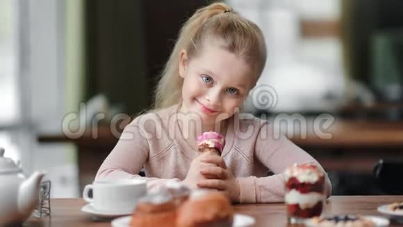 小女孩在咖啡馆里摆着冰淇淋角的肖像中型近距离拍摄4k红色相机视频的预览图